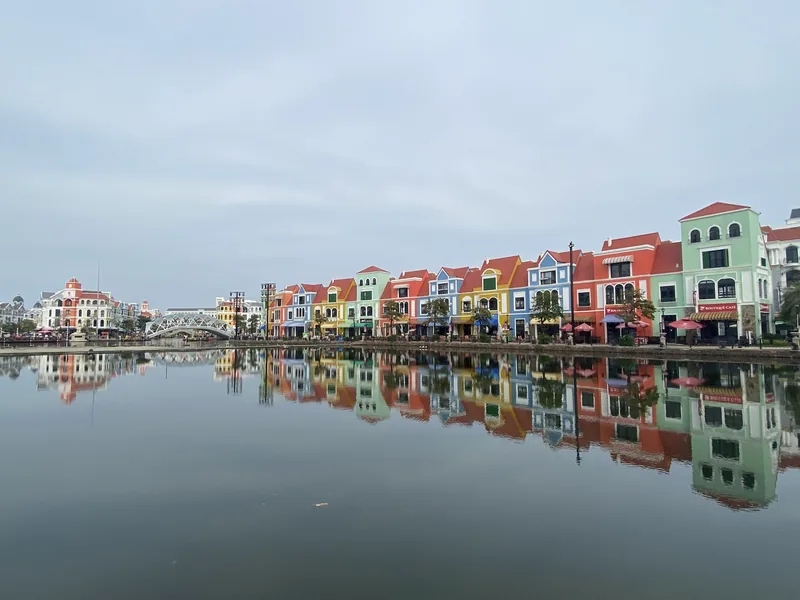 Colorful European-style townhouses line a calm canal at Phu Quoc, their facades mirrored in the still water.