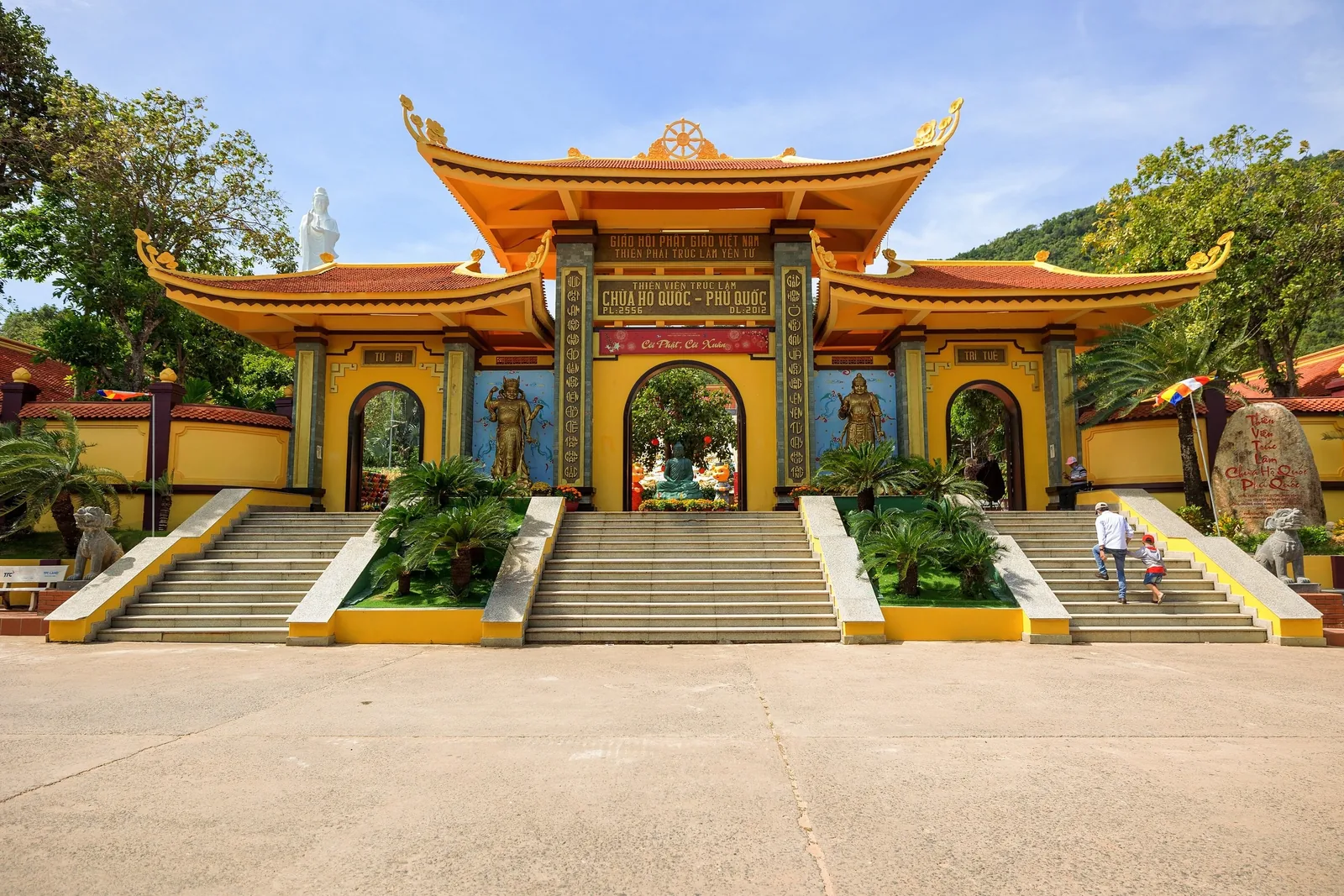 The ornate entrance gate of Ho Quoc Pagoda with red-tiled roofs and stone stairways in Phu Quoc.