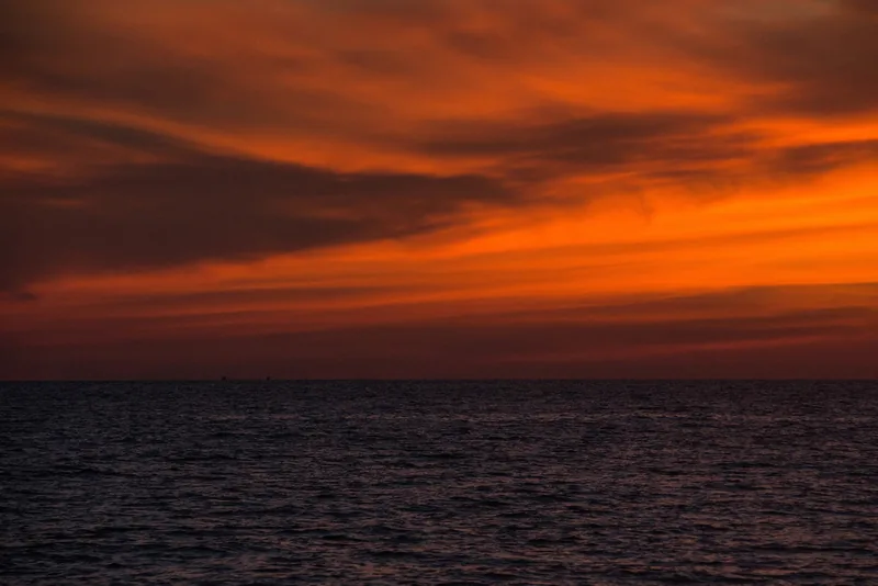 Fiery orange sunset clouds over the calm sea at Long Beach in Phu Quoc island. Fiery orange sunset clouds over the calm sea at Long Beach in Phu Quoc island.