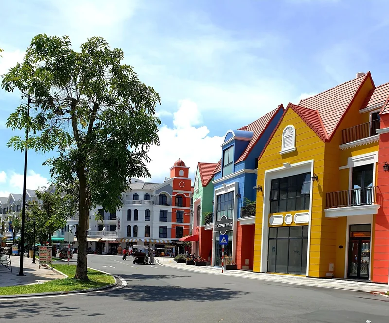 Colorful European-style shophouses line a quiet street under a blue sky in Phu Quoc. Colorful European-style shophouses line a quiet street under a blue sky in Phu Quoc.