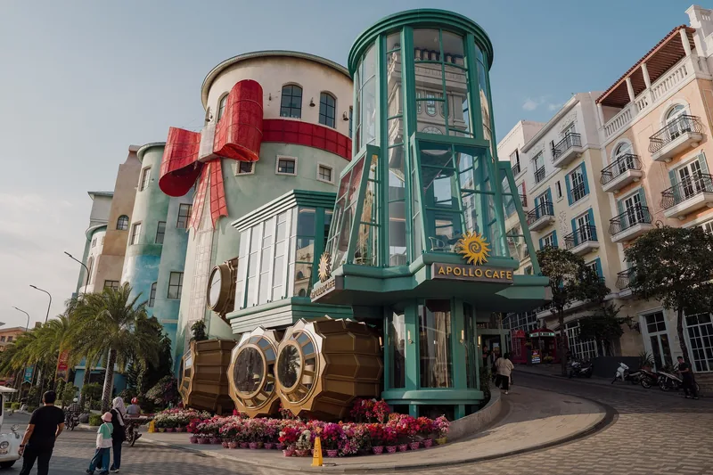 Whimsical steamship-shaped Apollo Cafe building with quirky architecture on a flower-lined street in Phu Quoc.