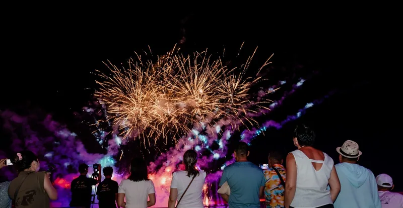 Crowd watches a golden fireworks display light up the night sky over Phu Quoc.