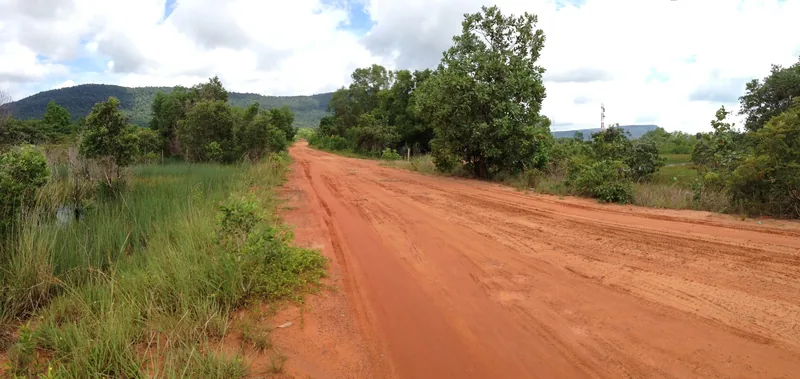 A red dirt road stretches through green forest and hills near Rach Ham Ninh on Phu Quoc island.